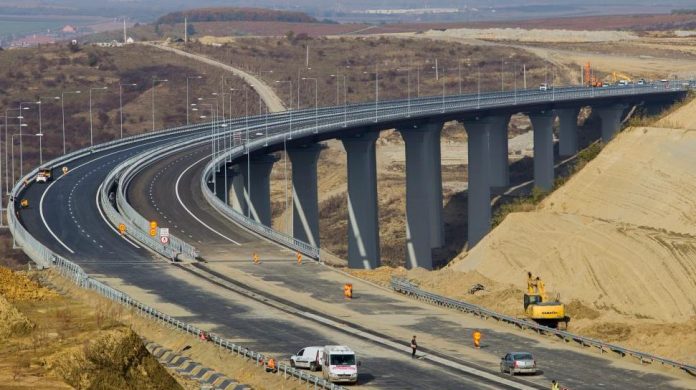 Autostrada Sibiu–Pitești, infrastructură, construcții, Munții Carpați, tuneluri, viaducte, Sibiu, Pitești, coridor pan-european IV, A1, drum expres, Valea Oltului, trafic, transport, DN7, blocaje, accidente, tronsoane, Sibiu–Boița, Boița–Cornetu, Cornetu–Tigveni, Tigveni–Curtea de Argeș, Curtea de Argeș–Pitești, foraj, geologie, instabilitate, versanți, consolidare, tehnologie modernă, seism, coridoare ecologice, urși, lupi, capre negre, mediu, protecție, zone protejate, fonduri europene, POIM, buget de stat, finanțare, investiții, termene, calitate, execuție, procente, mobilizare, muncitori, utilaje, lucrări nocturne, economie, competitivitate, turism, siguranță rutieră, investiții, transportatori, combustibil, experți, ritm de lucru, întârzieri, costuri suplimentare, modificări proiect, realități teren, conectivitate rutieră, veriga lipsă, A1 completă, coridor logistic, port Constanța, integrare TEN-T, atractivitate logistică, dezvoltare regională, reducere timp, eficiență, impact economic, impact social, regiunile traversate, investiții noi, constructori, antreprenori generali, subantreprenori, firme românești, firme străine, licitații, contracte, acorduri, exproprieri, relocare utilități, drumuri provizorii, organizare șantier, monitorizare proiect, raportare progres, comunicare publică, conferințe presă, imagini satelit, hărți proiect, planificare, termene intermediare, strategie finalizare.